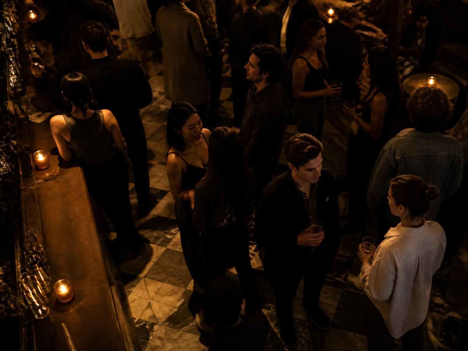 A crowded, candlelit New York bar seen from above